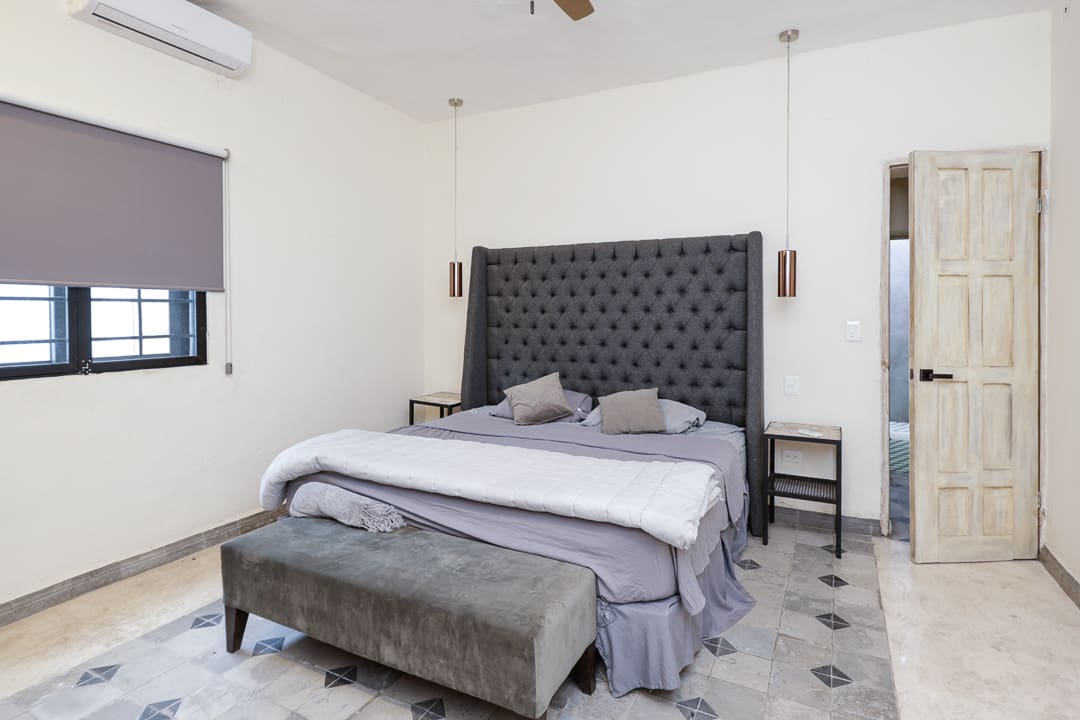 Modern bedroom with tufted headboard and bench.