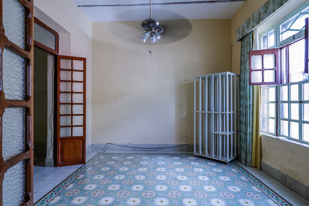 Empty room with patterned tile floor and ceiling fan.
