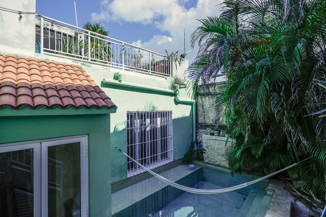 Cozy backyard pool area with greenery and a tiled roof.