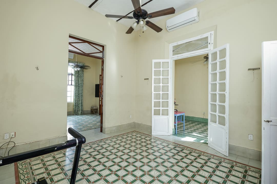 Empty room with patterned floor tiles and ceiling fan.