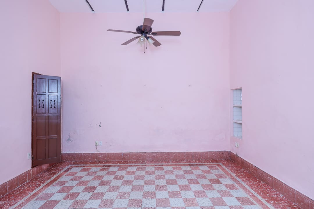 Empty room with checkered floor and ceiling fan.