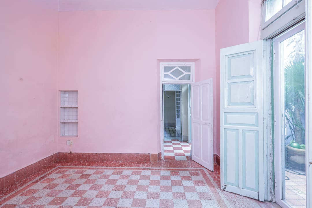 Empty room with pink walls and checkered floor.