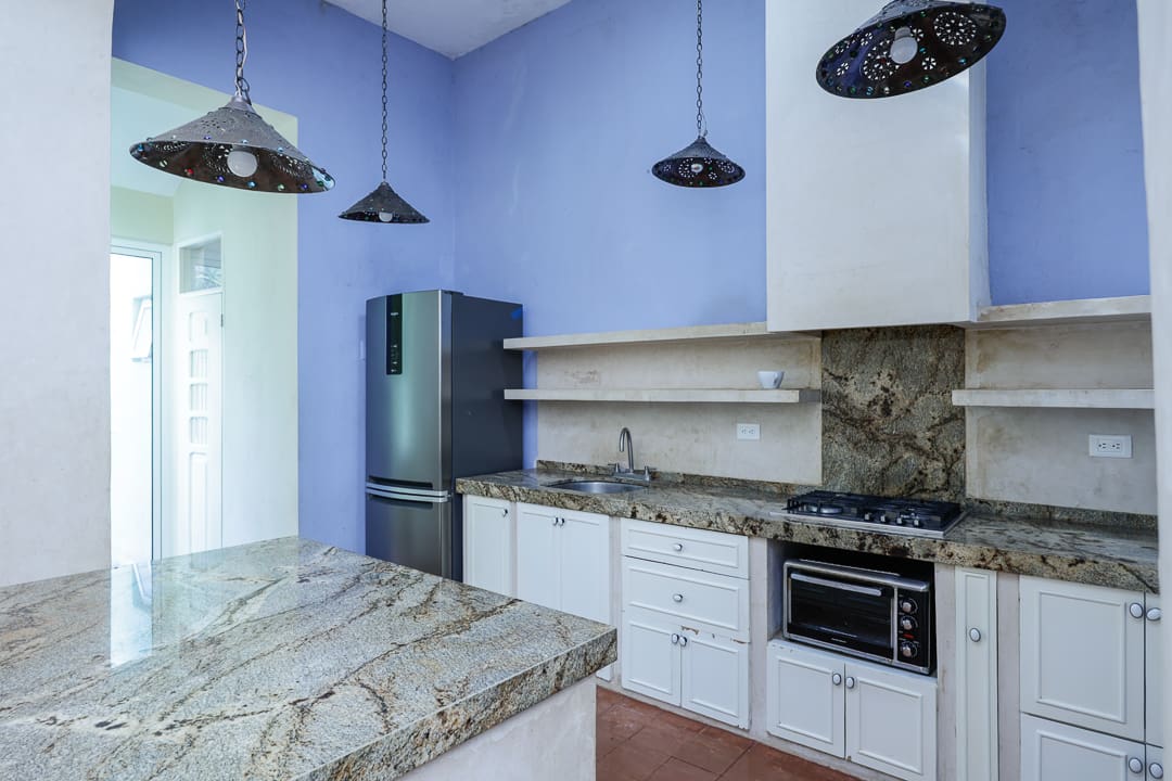 Modern kitchen with marble countertops and stainless steel appliances.
