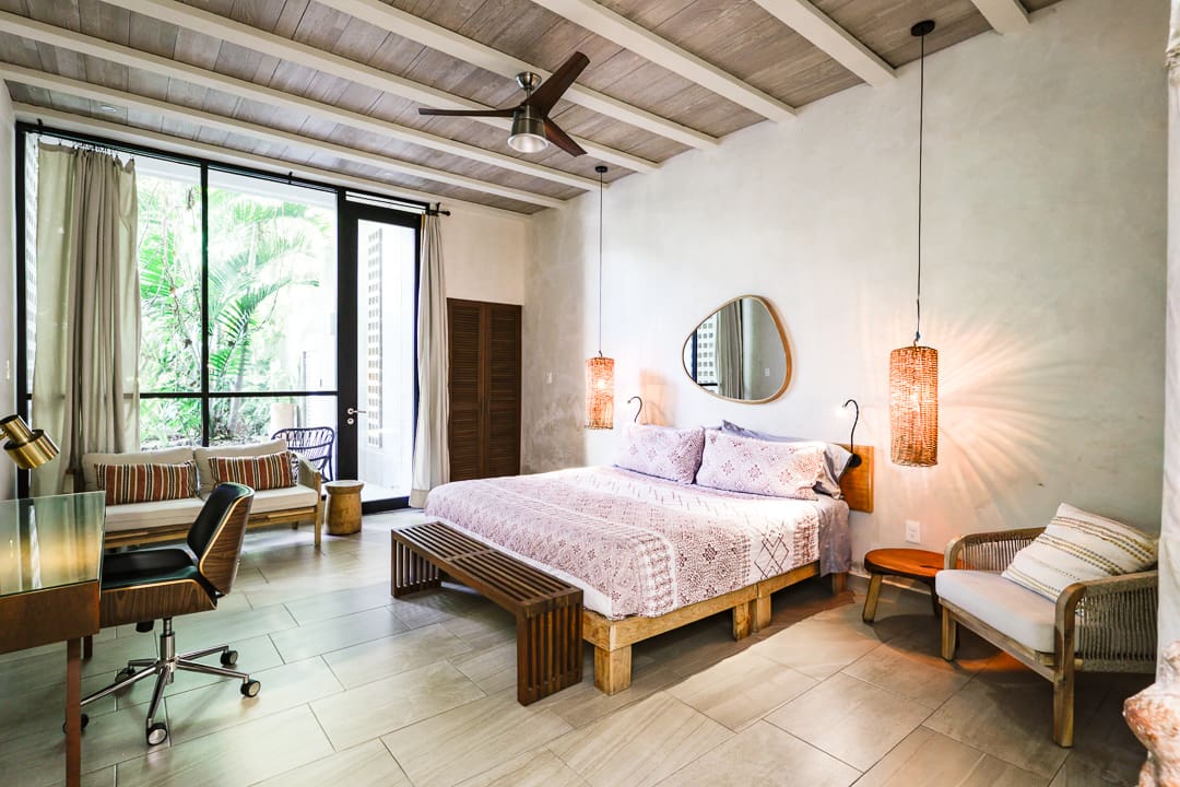 Bright bedroom with wooden bed and ceiling fan.