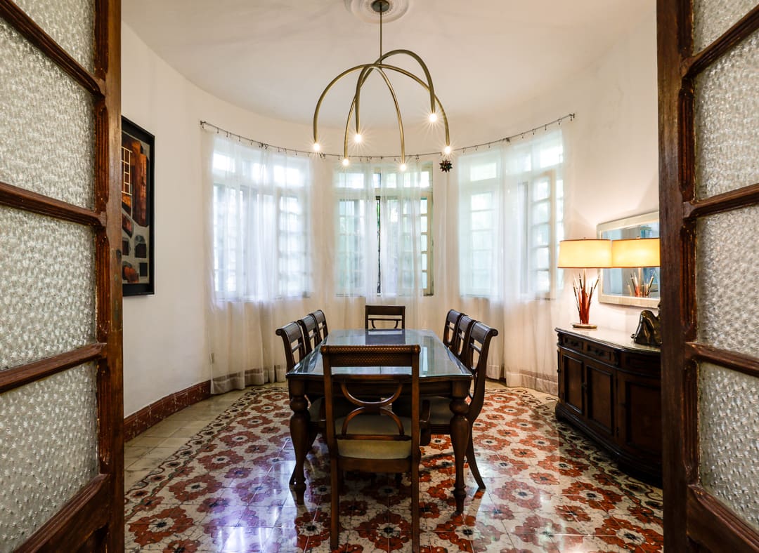 Elegant dining room with vintage-style chairs and patterned tile flooring.