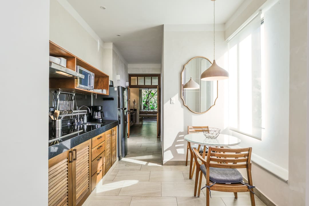 Bright kitchen with wooden cabinets and a cozy dining area by a large window.