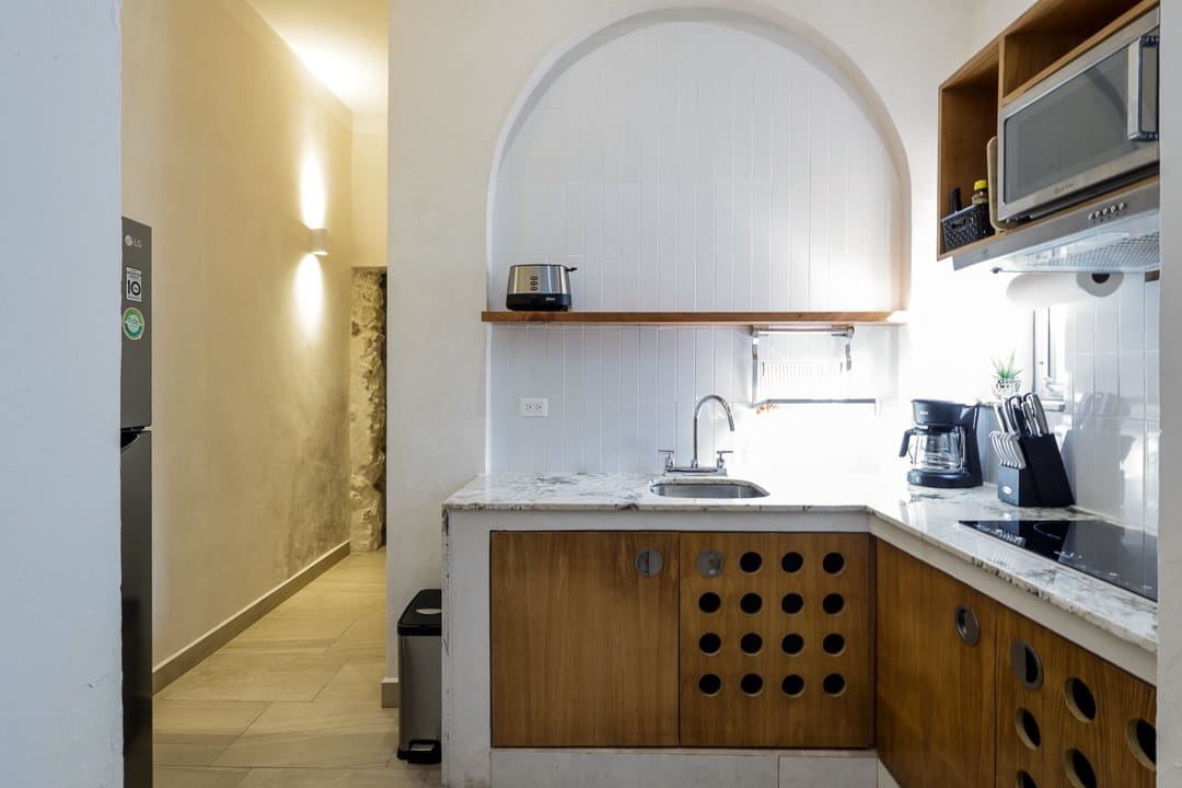 Cozy kitchen corner with wooden cabinets and white tiled backsplash.