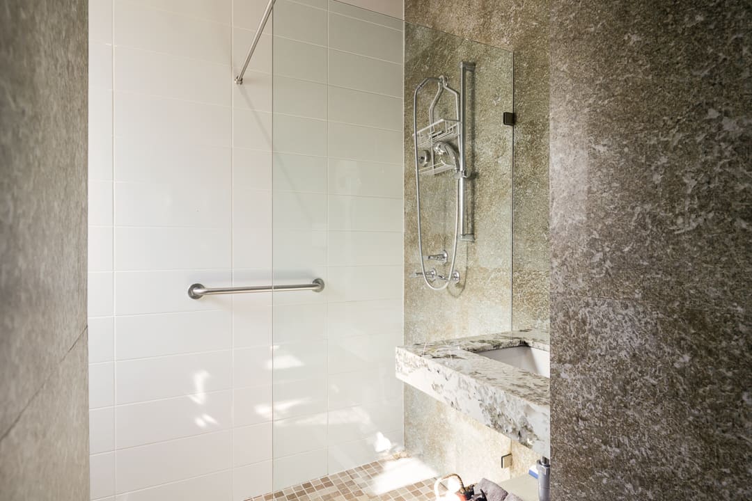 A modern bathroom with a glass shower and marble accents.