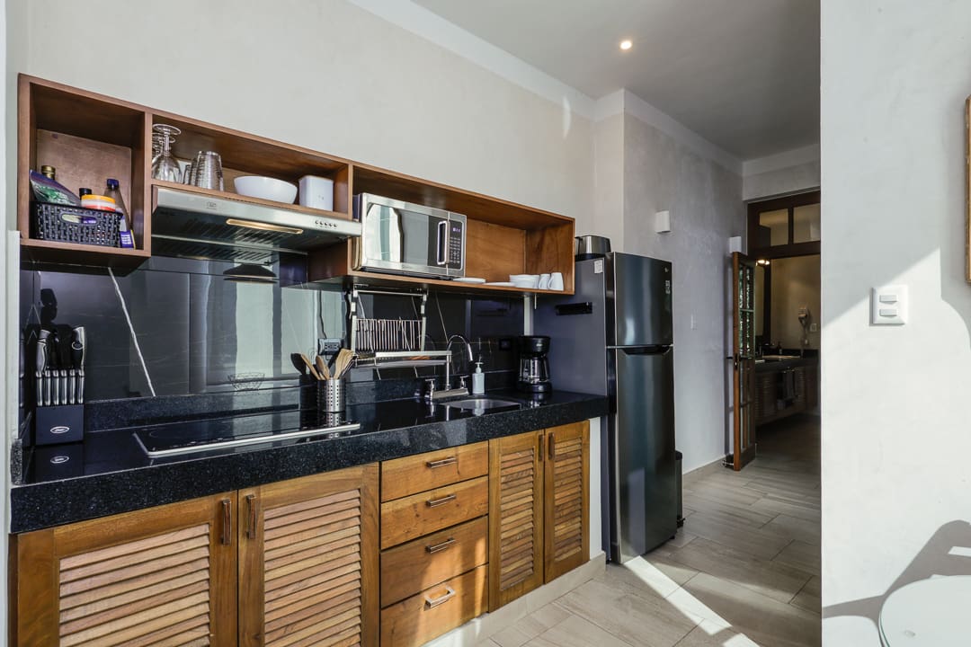 Modern kitchen with wooden cabinets and black countertops.