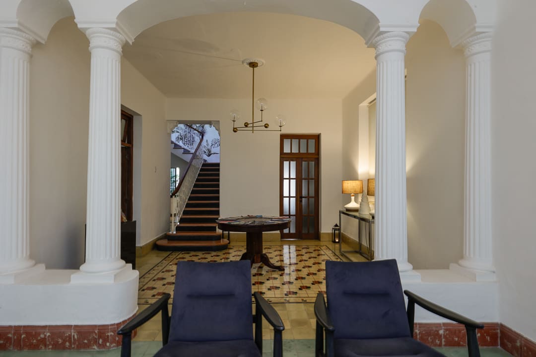 Cozy living room with classic columns and elegant staircase.