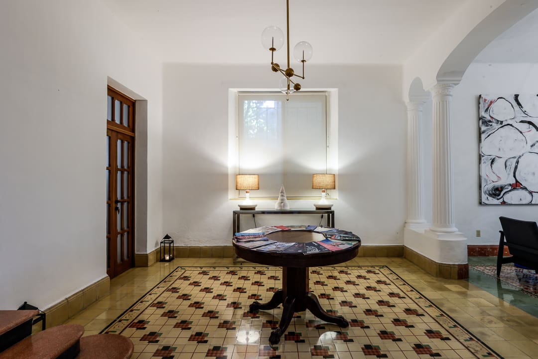 Elegant vintage room with a round table and a double bed under soft lighting.