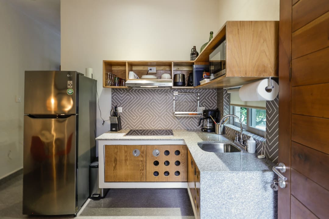 Modern kitchen with wooden cabinets and marble countertops.