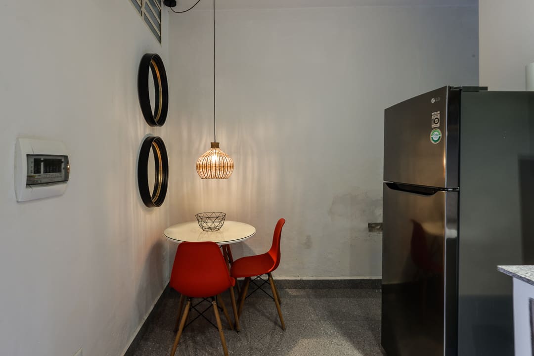 Cozy dining nook with red chairs and a modern pendant light.