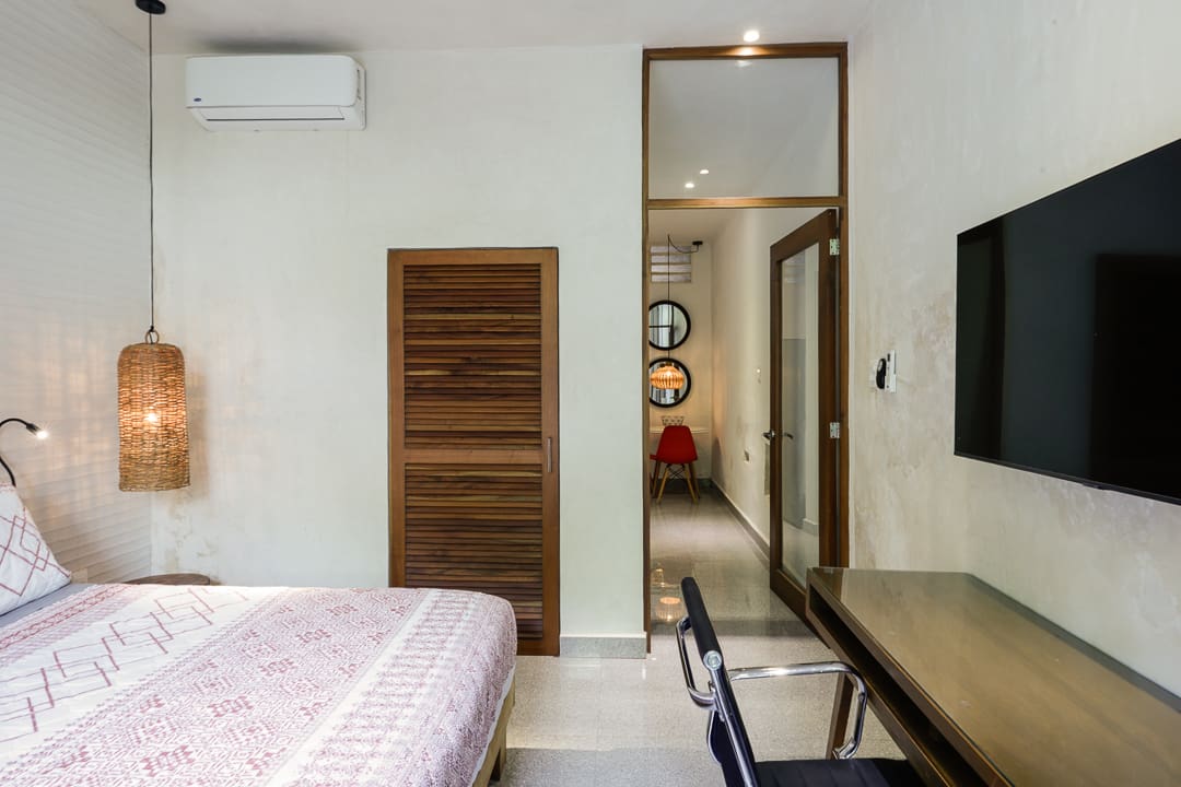 Cozy bedroom with a wooden wardrobe and a sleek workspace.