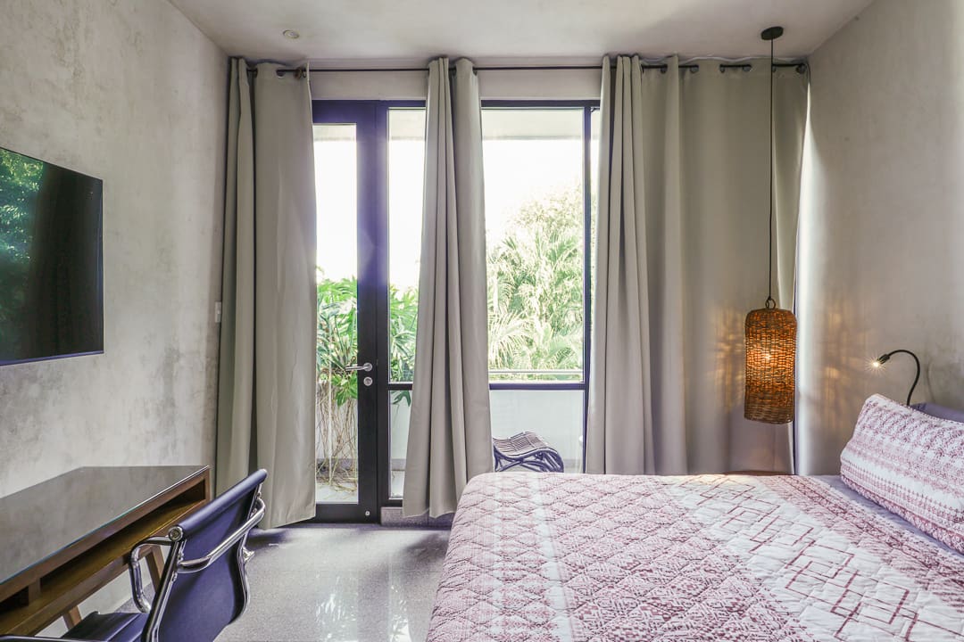 Cozy bedroom with large windows and light curtains.