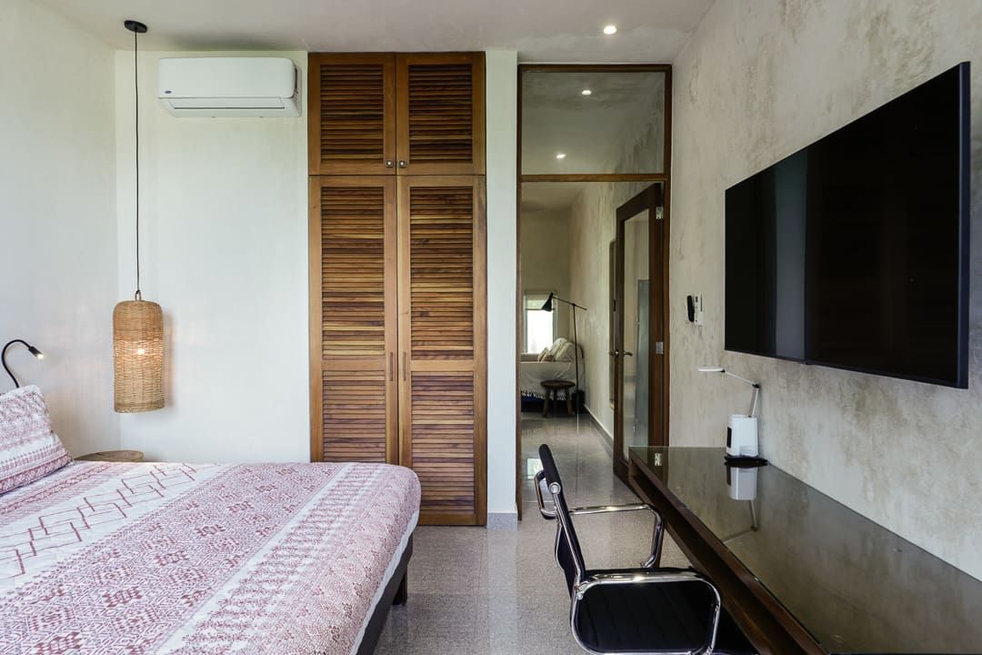 Modern bedroom with wooden closet doors and a sleek workspace.