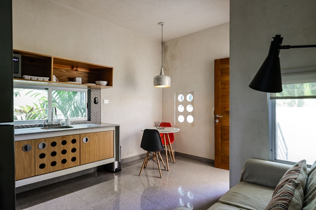 Modern kitchen corner with wooden cabinets and a small dining table.