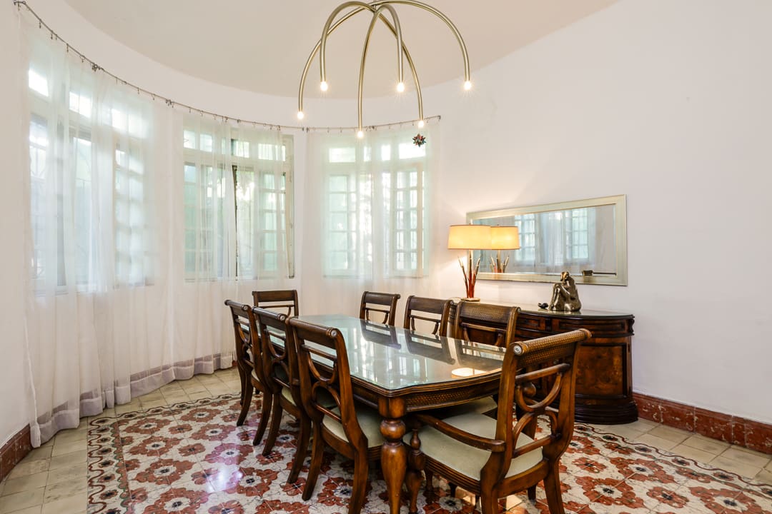 Elegant dining room with classic wooden furniture and large windows.