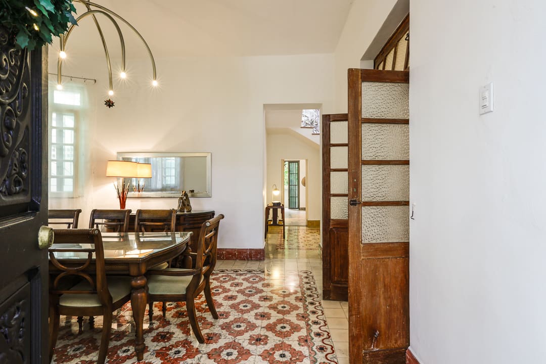 Elegant dining room with vintage tiled floor and wooden furniture.