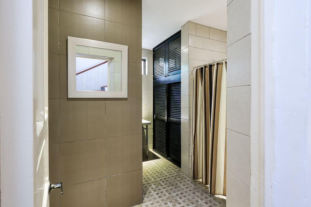 Modern bathroom with beige tiles, a walk-in shower, and a curtain.
