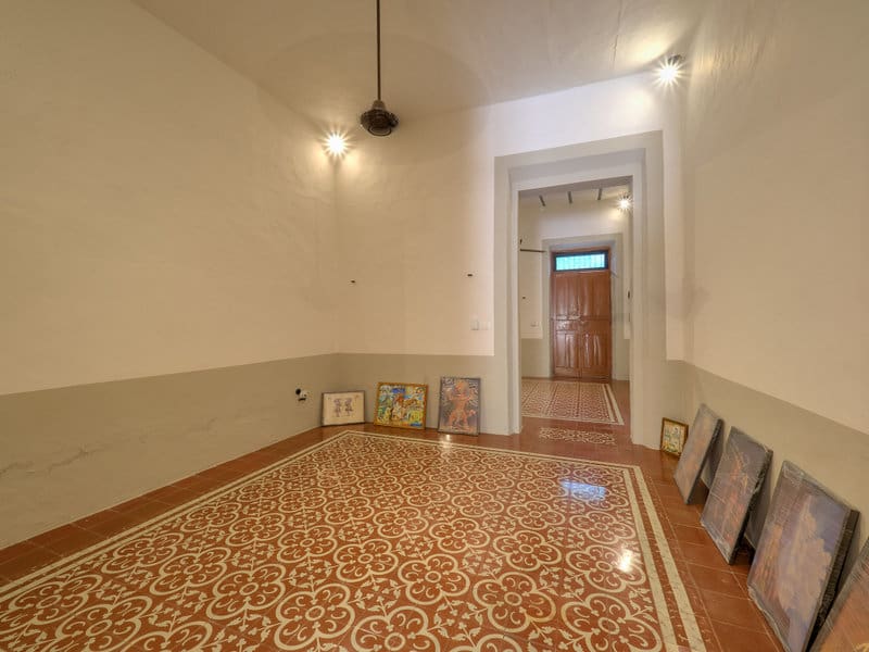Empty room with patterned floor tiles and soft lighting.