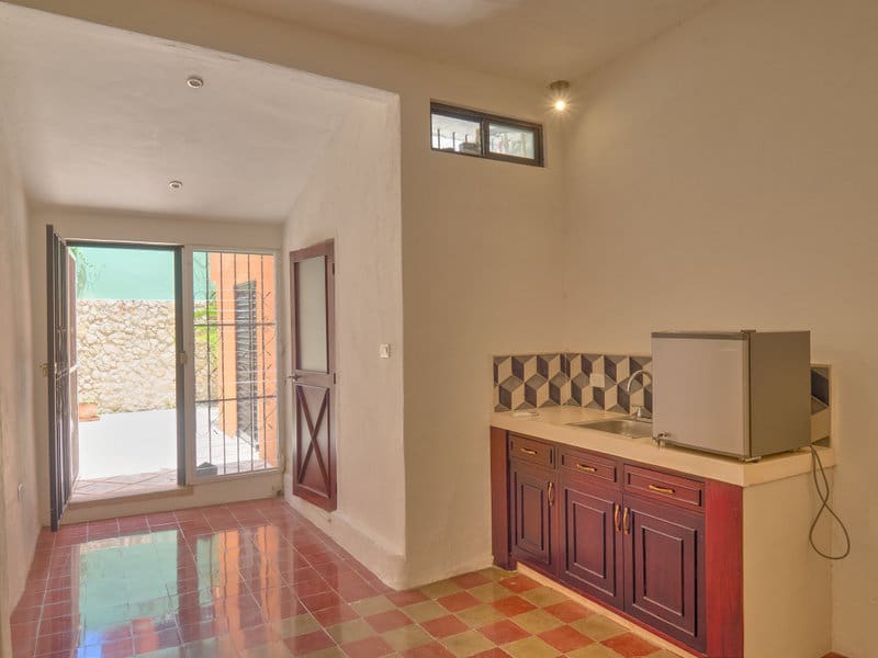 Empty room with tiled floor and wooden cabinet under a counter.