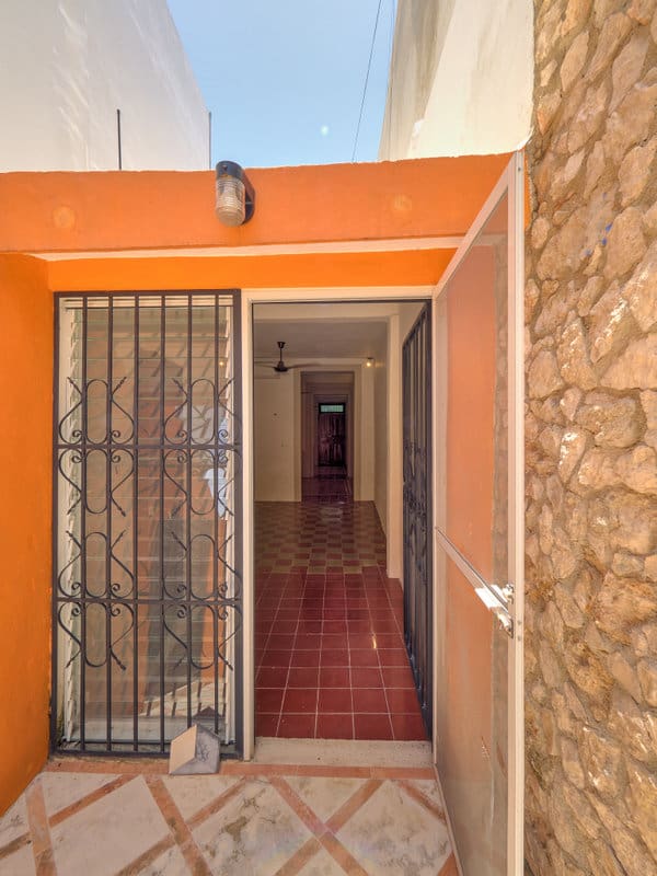 Open doorway leading into a narrow hallway with tiled floor.