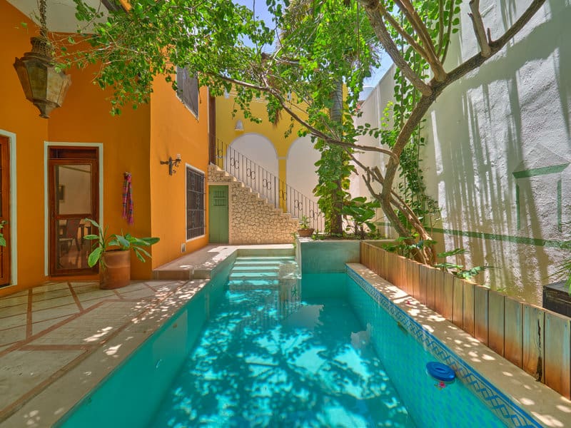 Cozy courtyard with a turquoise pool and lush greenery.