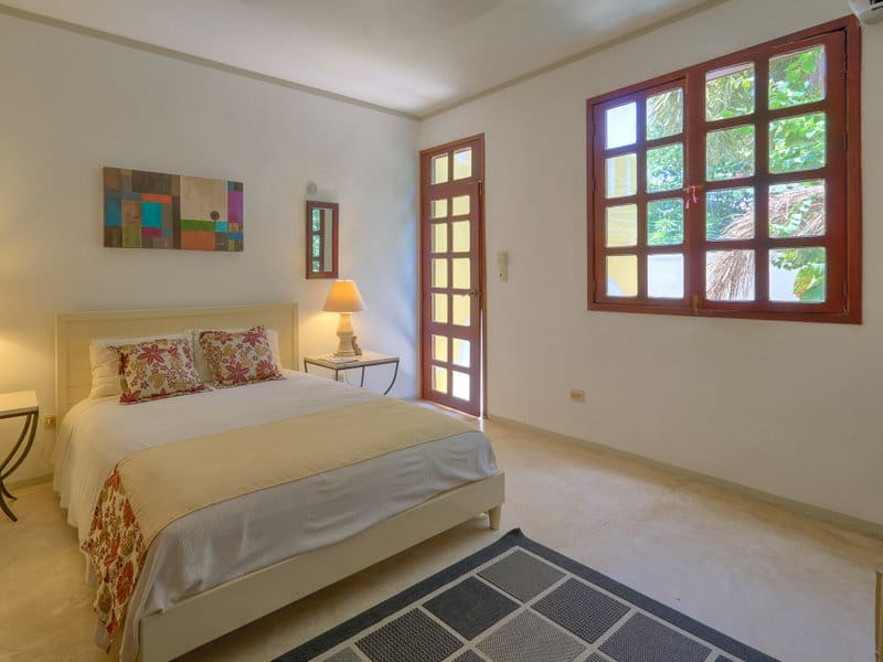 Cozy bedroom with warm lighting and large windows.