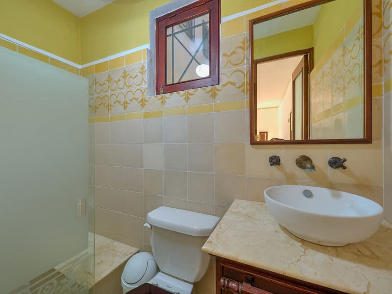 Small bathroom with toilet, sink, and shower area.