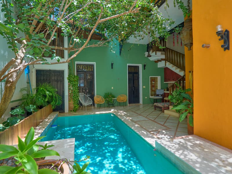 Cozy courtyard with a turquoise pool and lush greenery.