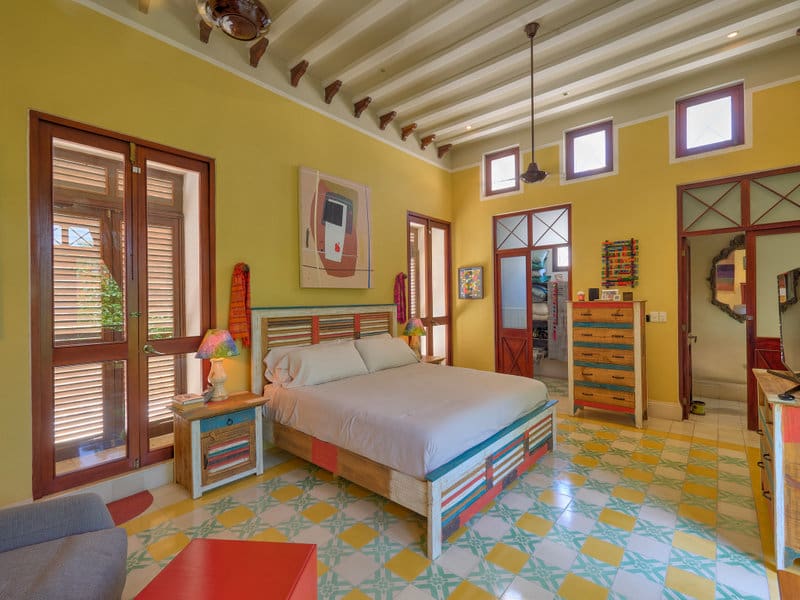 Bright bedroom with colorful tiles and wooden beams.