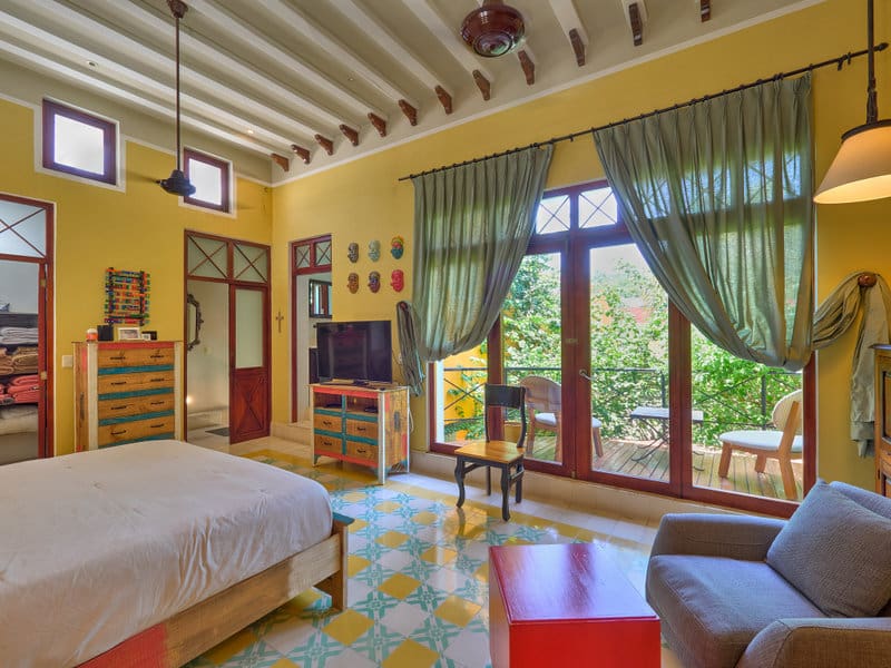 Cozy bedroom with large windows and colorful tiled floor.
