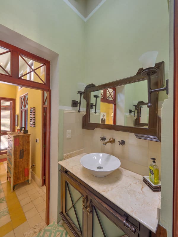 Cozy bathroom with a wooden-framed mirror and a modern sink.