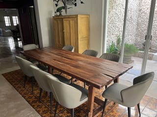 Wooden dining table with six chairs in a cozy room.