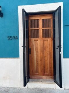 Wooden door framed by blue and white walls with the number 559A.