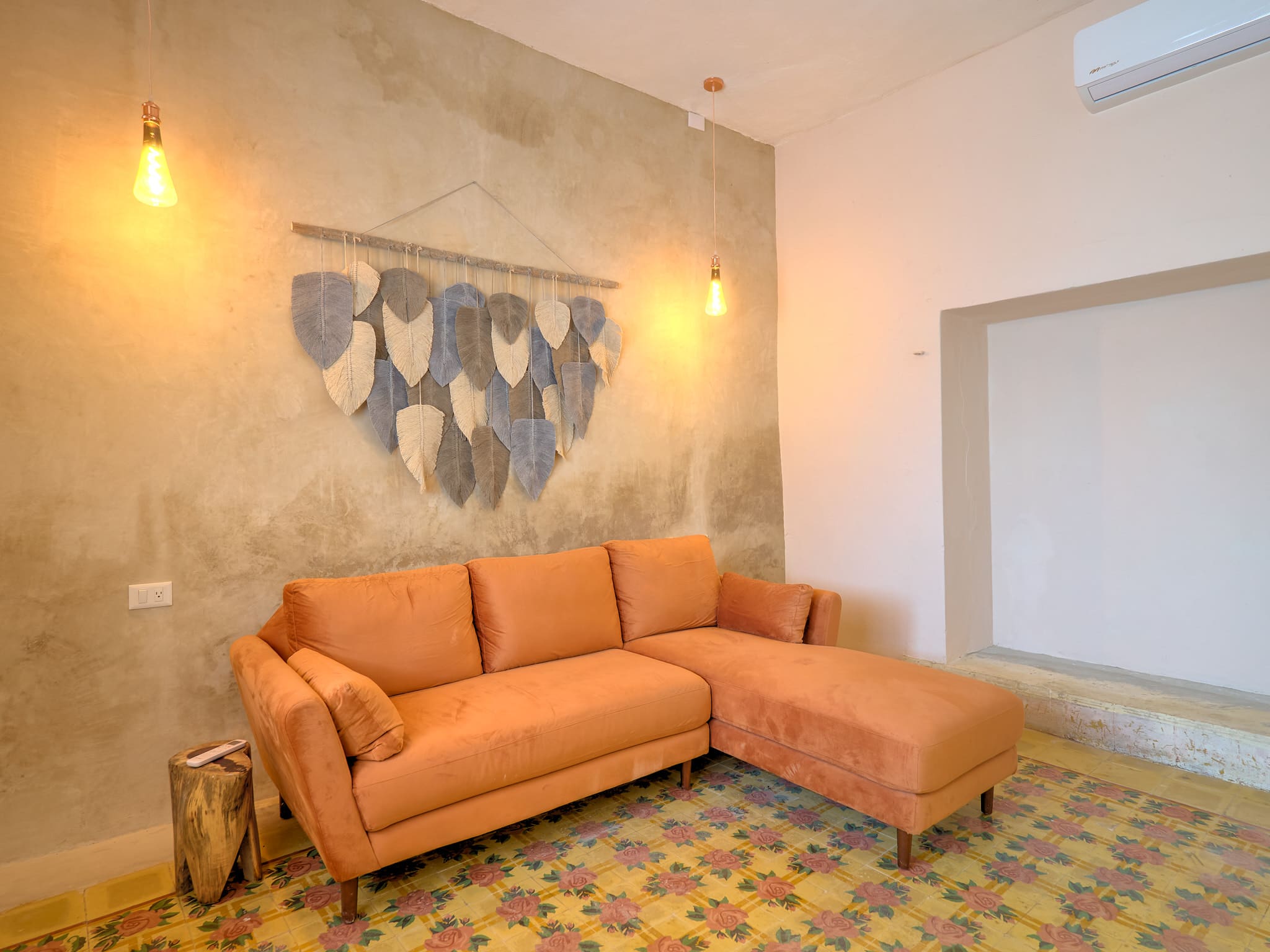 Cozy living room with a large orange sectional sofa and heart-shaped wall decor.