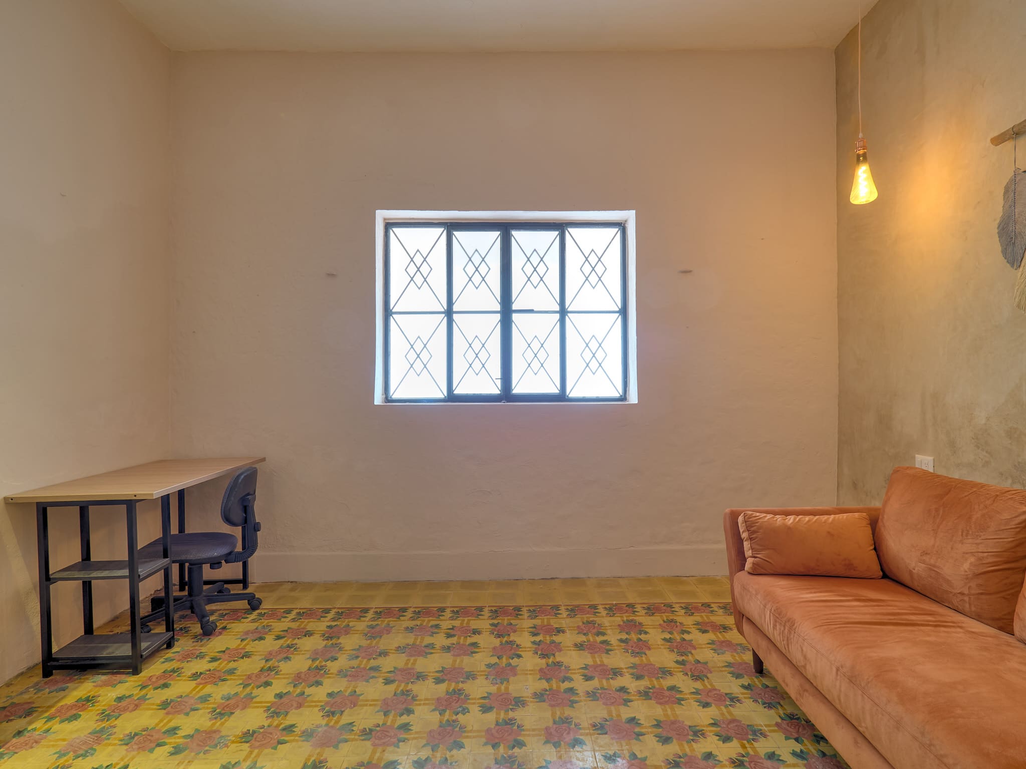 Minimalist room with vintage tiled floor and simple furniture.