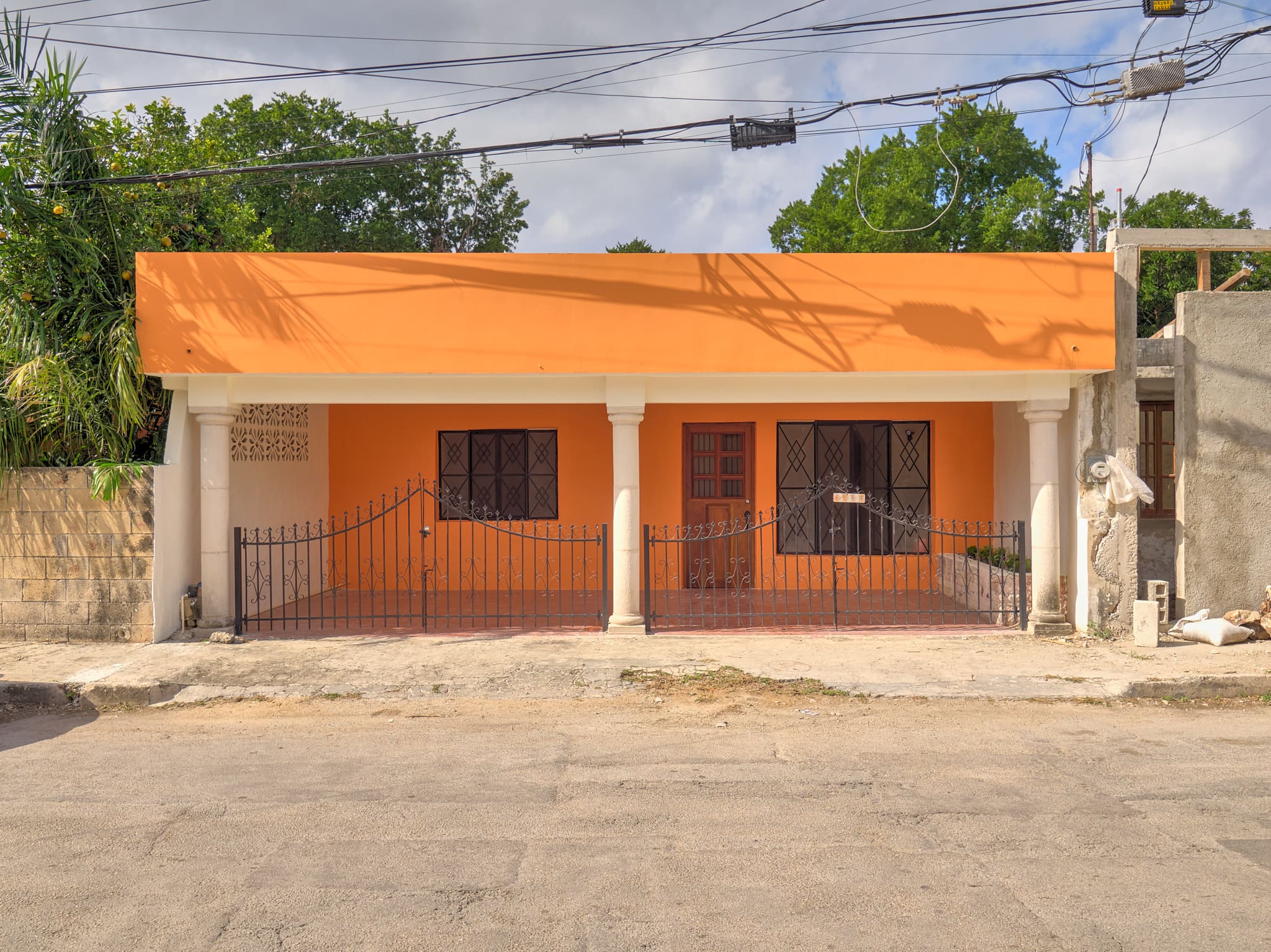 Single-story house with an orange roof and white exterior walls.