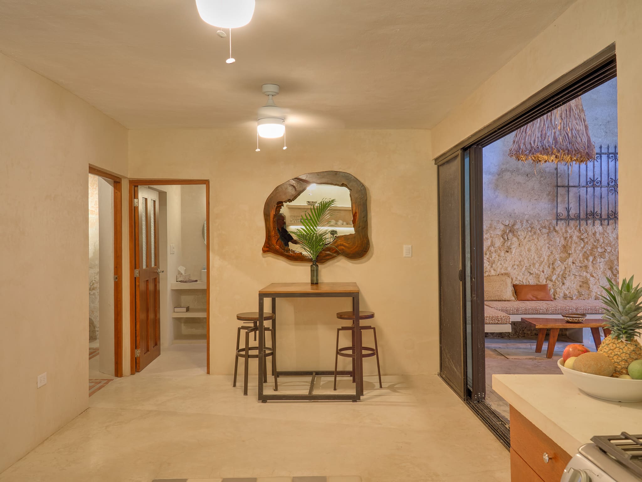 Cozy indoor space with a small table, chairs, and a large mirror on the wall.