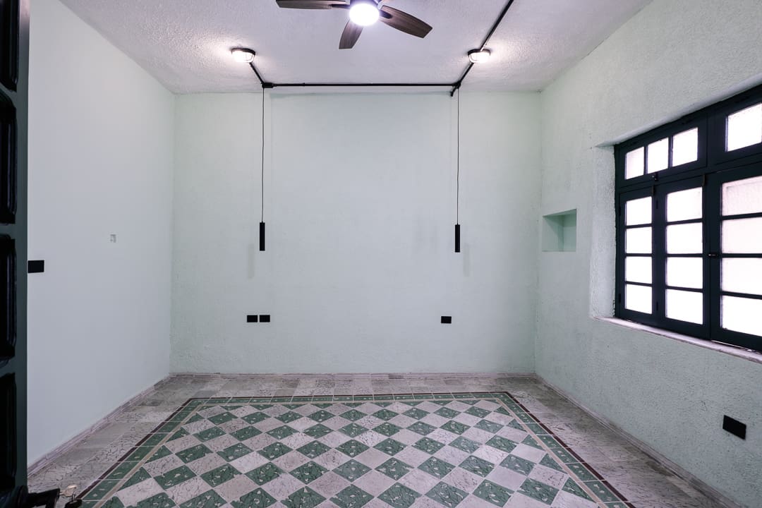 Empty room with tiled floor, hanging light bulbs, and ceiling fan.