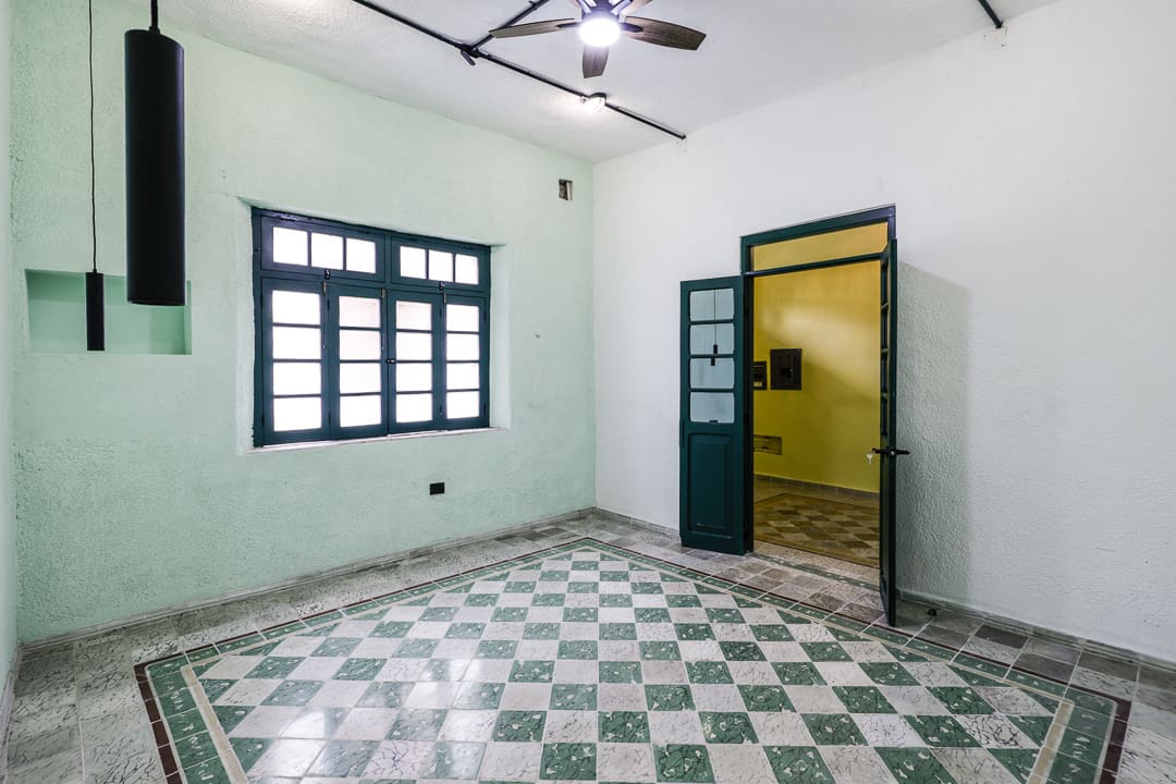 Empty room with checkered floor and ceiling fan.