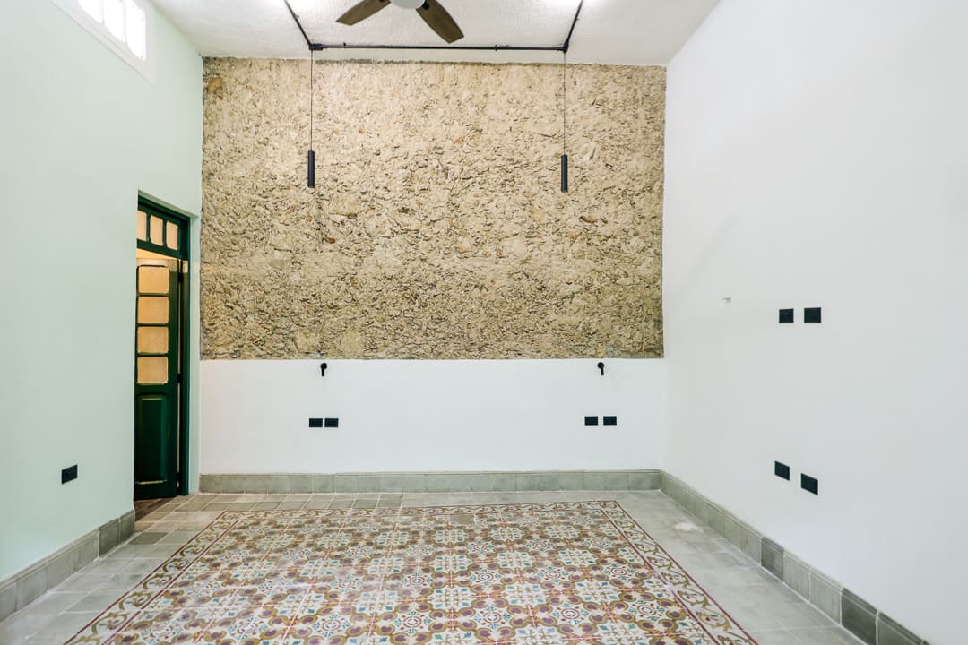 Empty room with patterned tile flooring and a large textured wall panel.