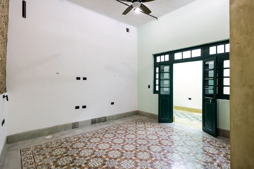 Empty room with white walls and patterned tile flooring.