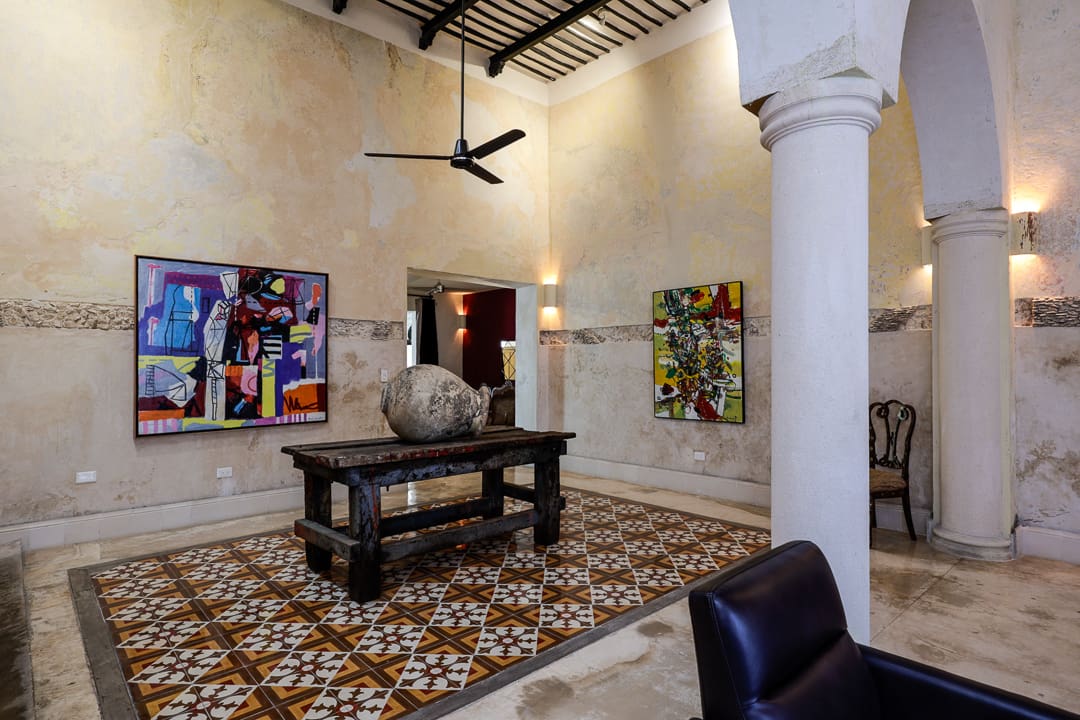 Art gallery room with colorful paintings and rustic decor.