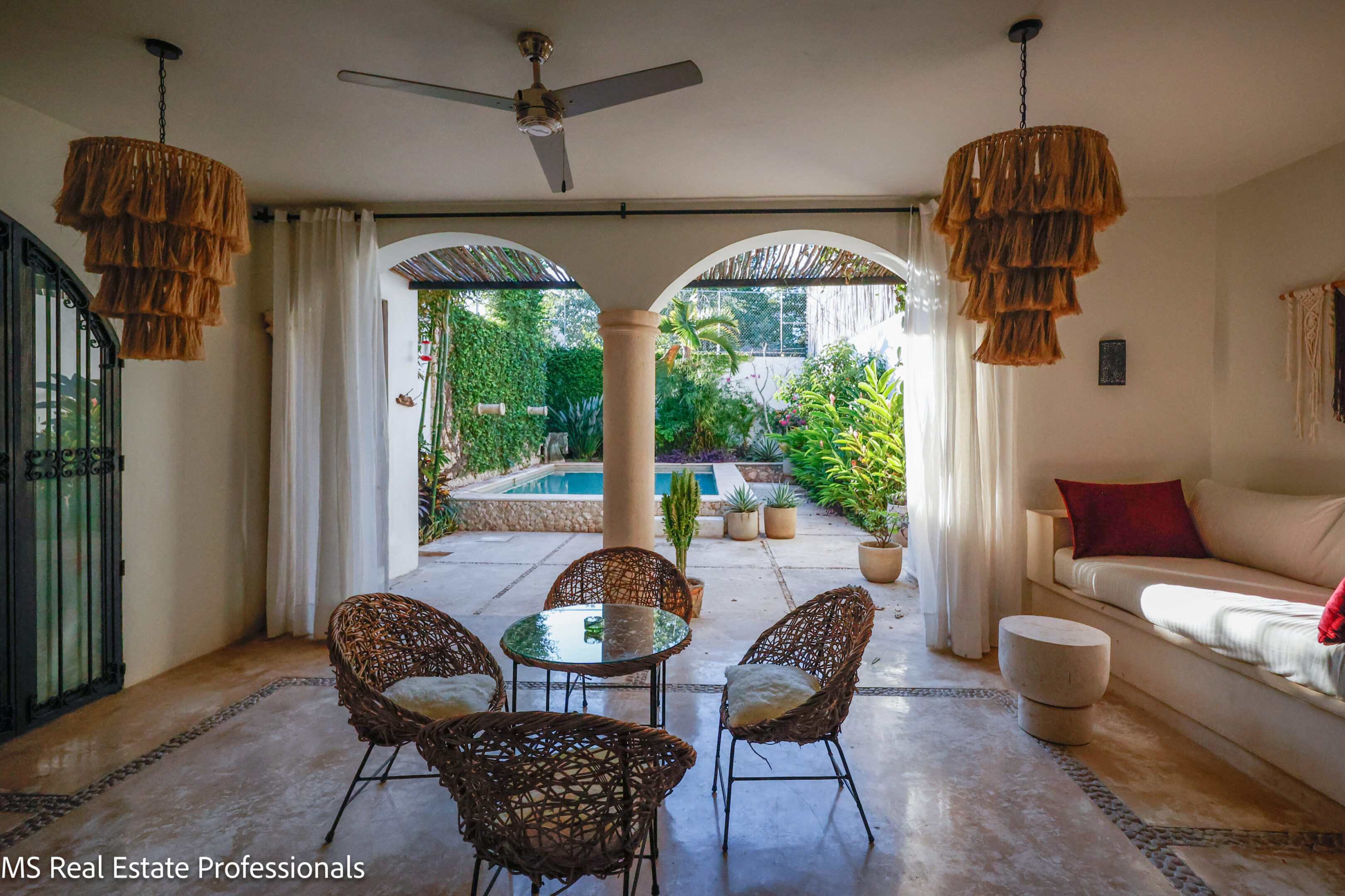 Cozy outdoor seating area with wicker chairs and arches.