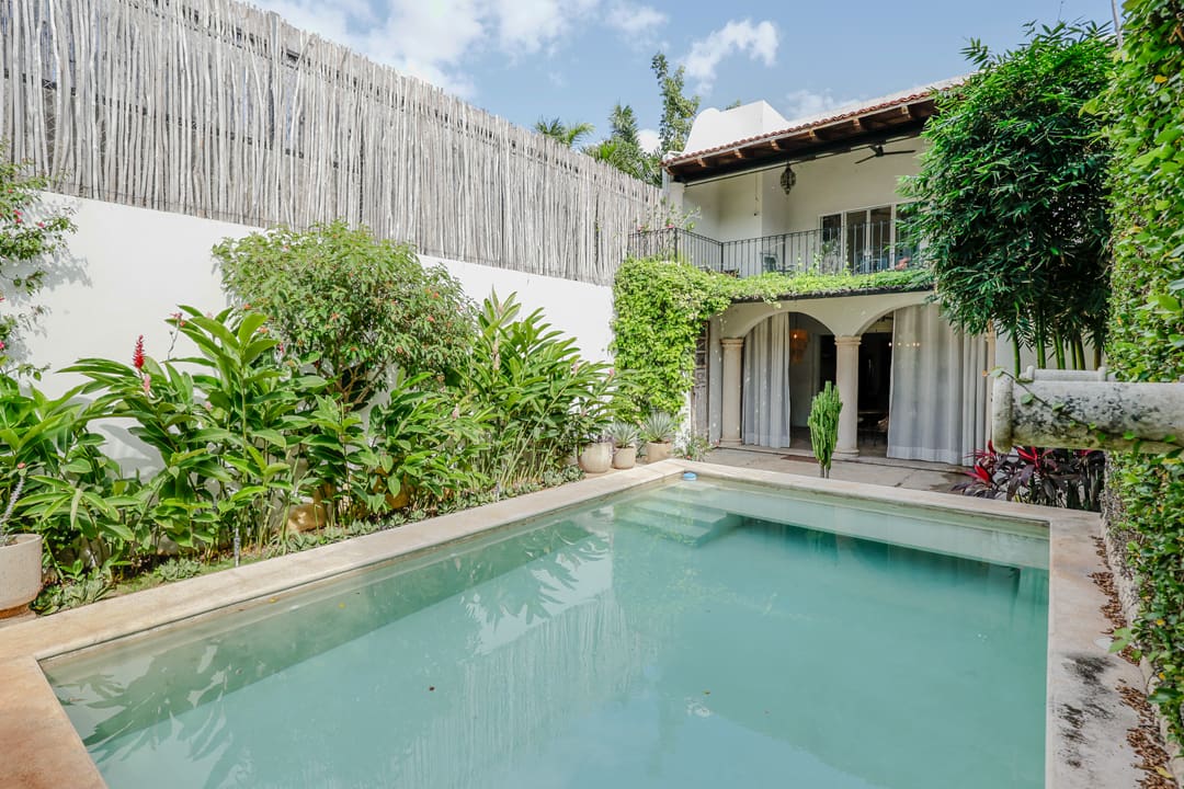 Tranquil courtyard with a clear swimming pool and lush greenery.