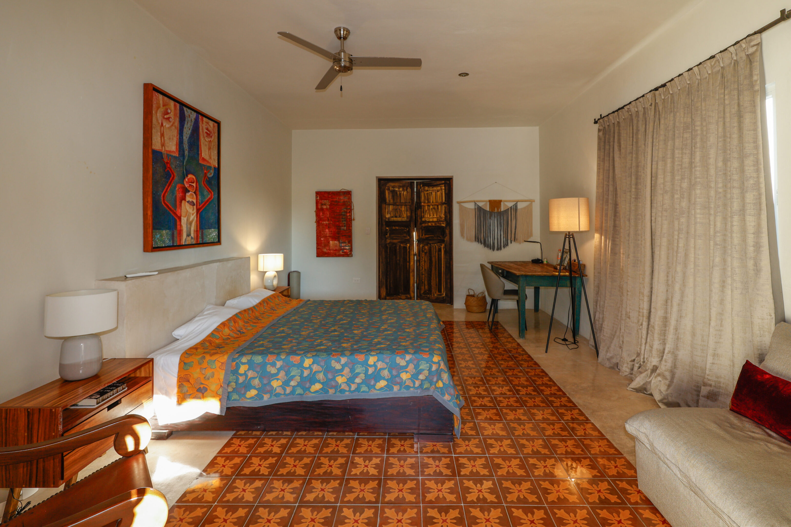 Cozy bedroom with colorful artwork and patterned flooring.