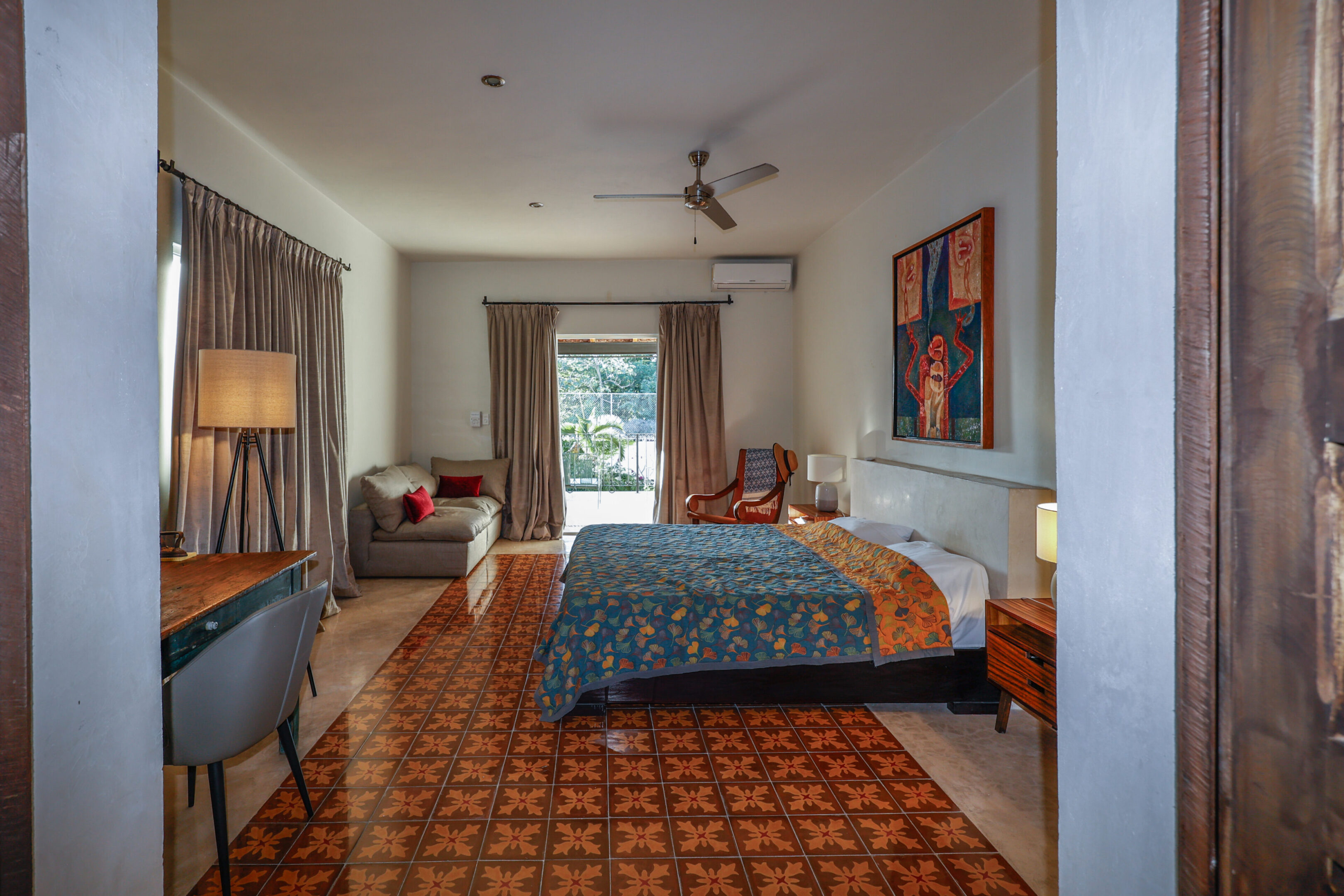 Cozy bedroom with patterned floor and blue bedding.