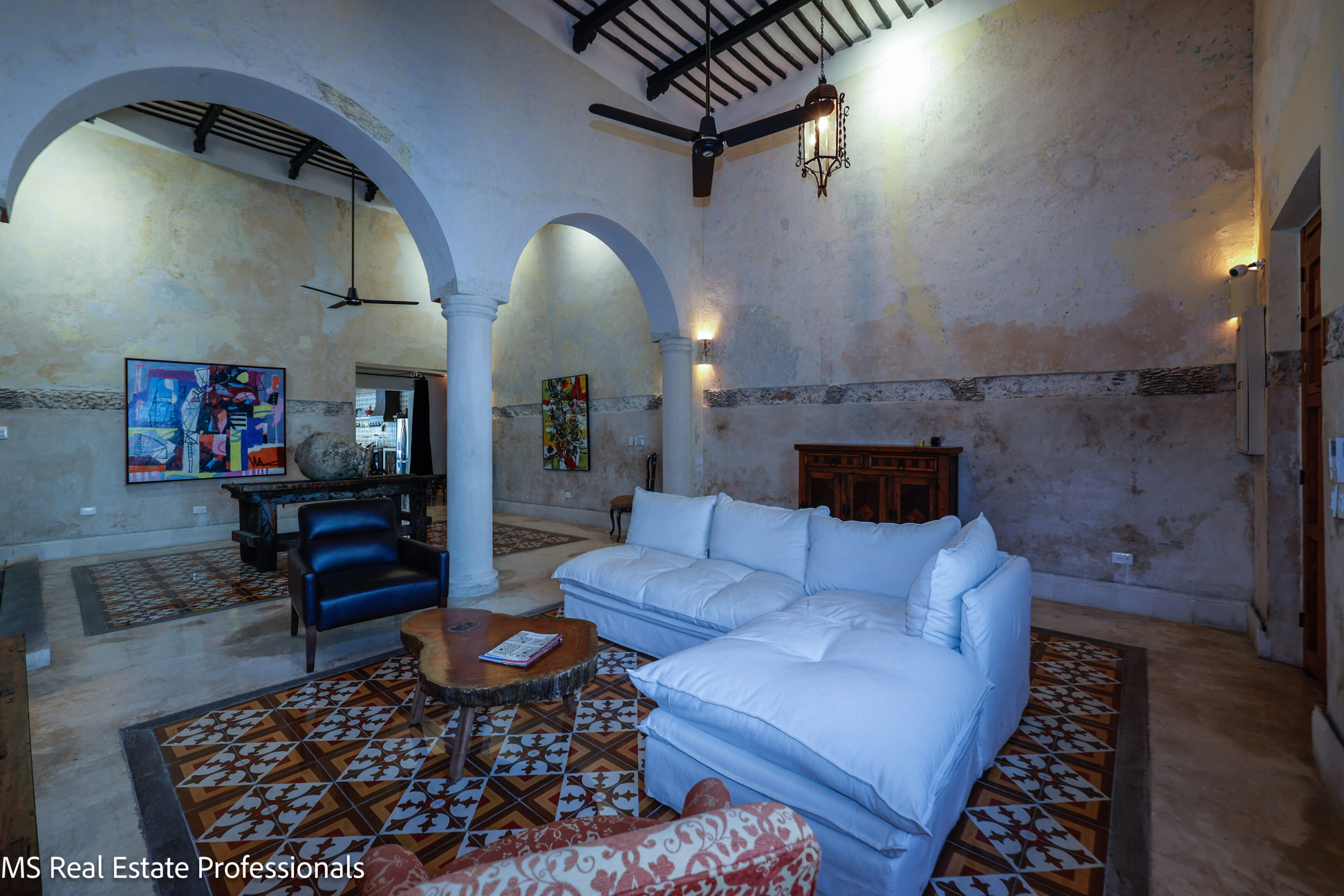 Cozy living room with white sofas and arched walls.